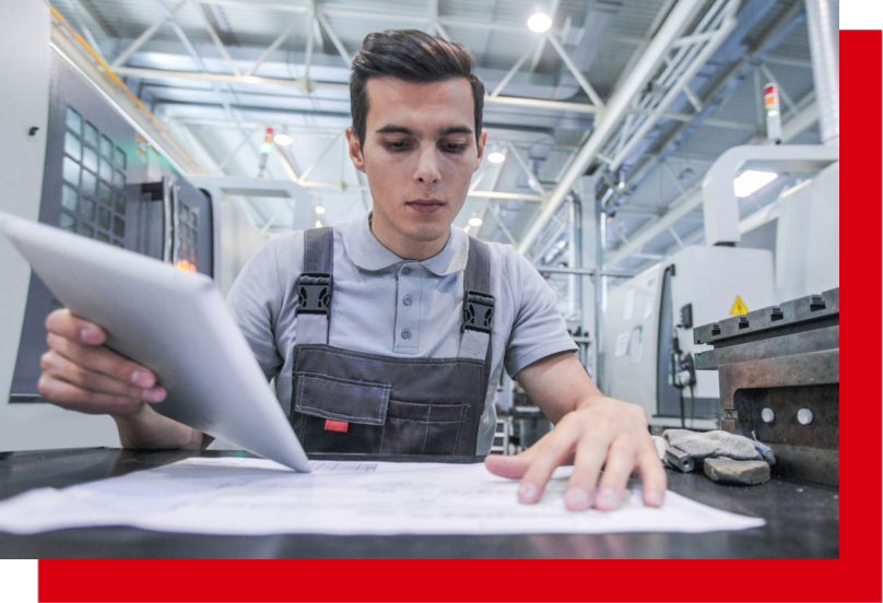 Un technicien vérifiant des plans de fabrication sur une tablette dans un atelier d'usinage moderne